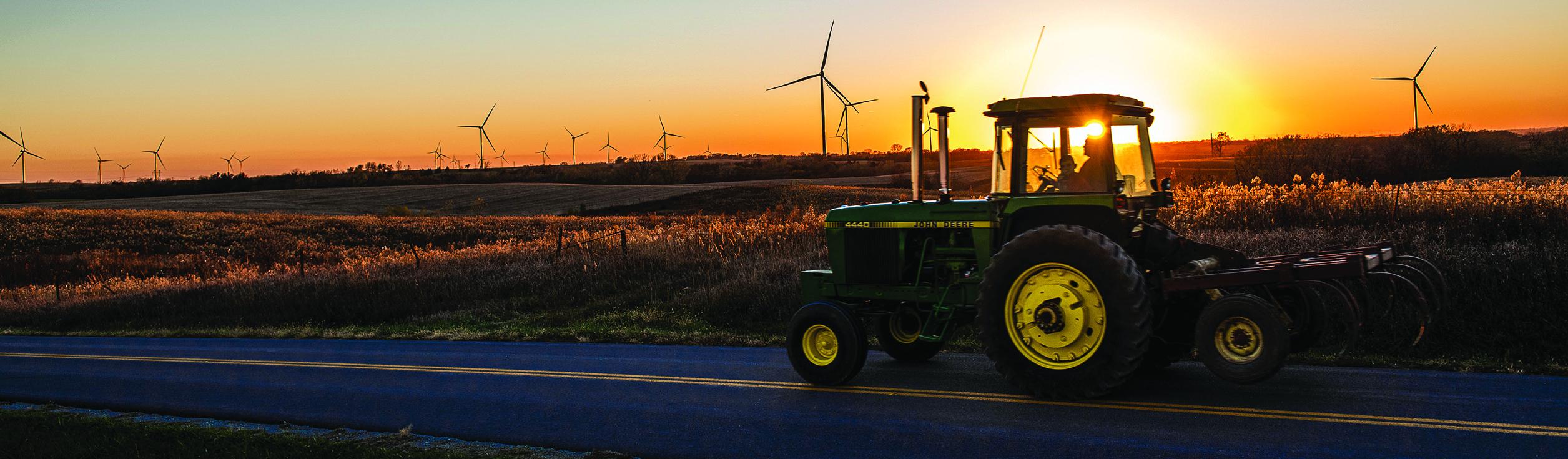 tractor driving past wind power sources